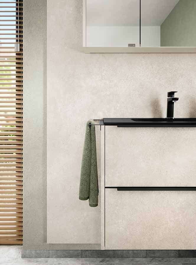 Schwarzes Waschbecken in heller Kommode Ein Schwarzes Waschbecken in heller Kommode mit einem grünen Handtuch