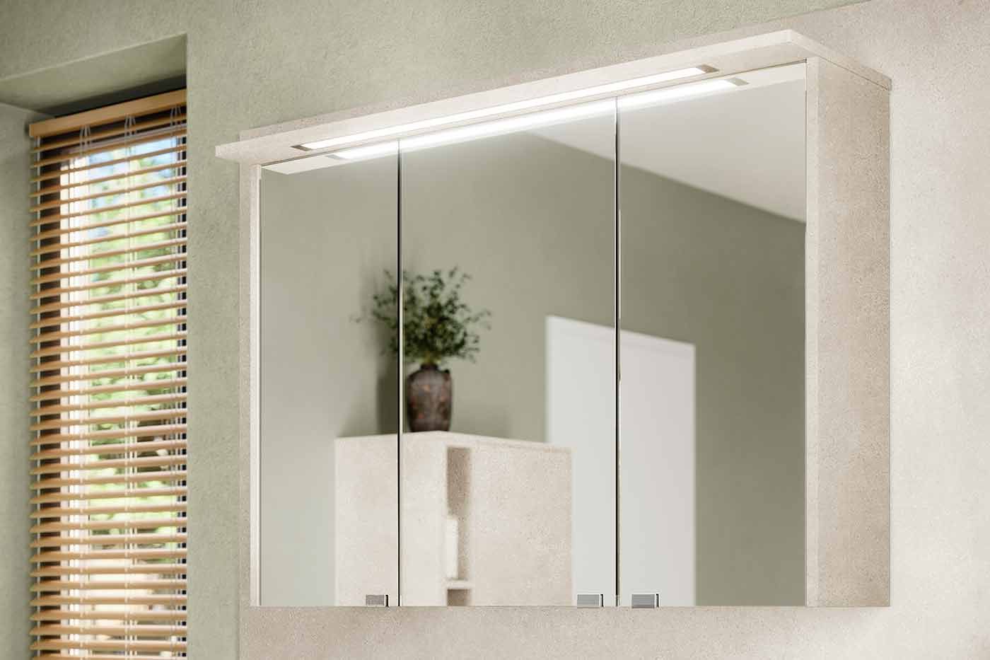 Ein an der Wand hängender Schrank mit verspiegelten Türen