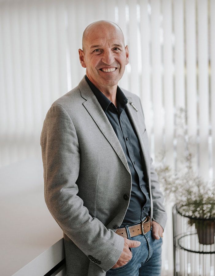 Lächelnder Mann mit grauem Blazer und blauem Hemd