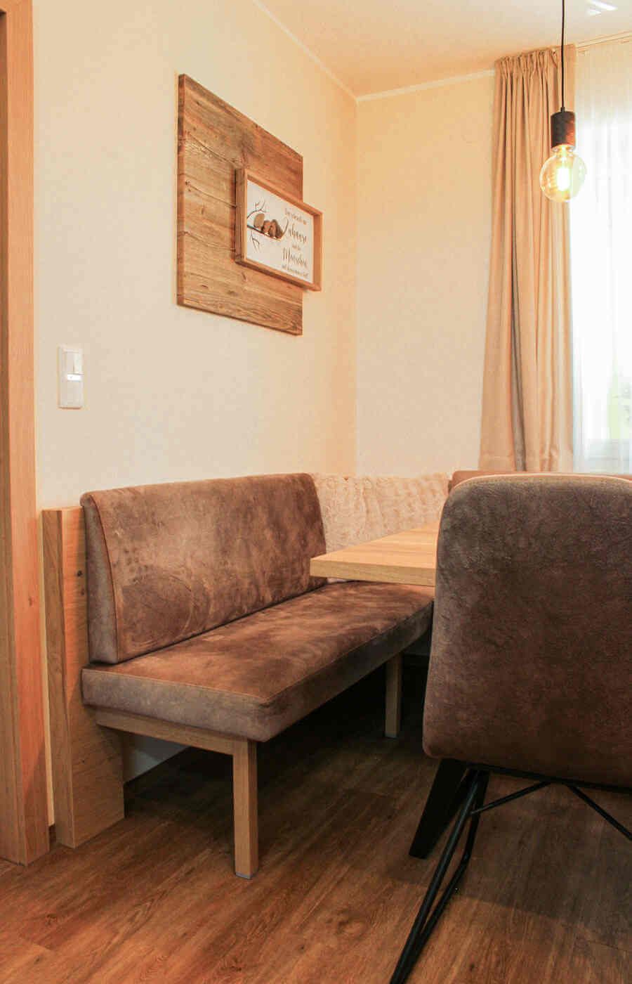 Essbereich mit einer brauen Sitzbank und Stühlen