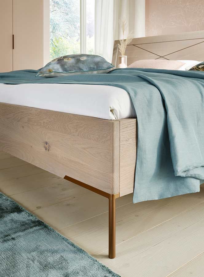 Bett Fußgestell aus Messing an einem Bett aus hellem Holz