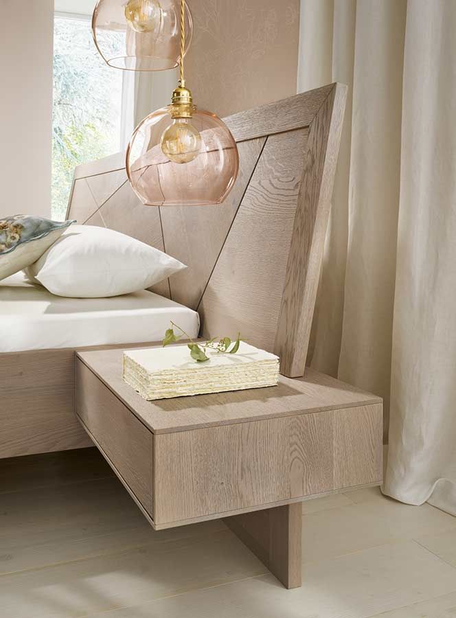 Betthaupt aus einem hellen Holz mit geometrischen Formen und einem integrierten Nachttisch 