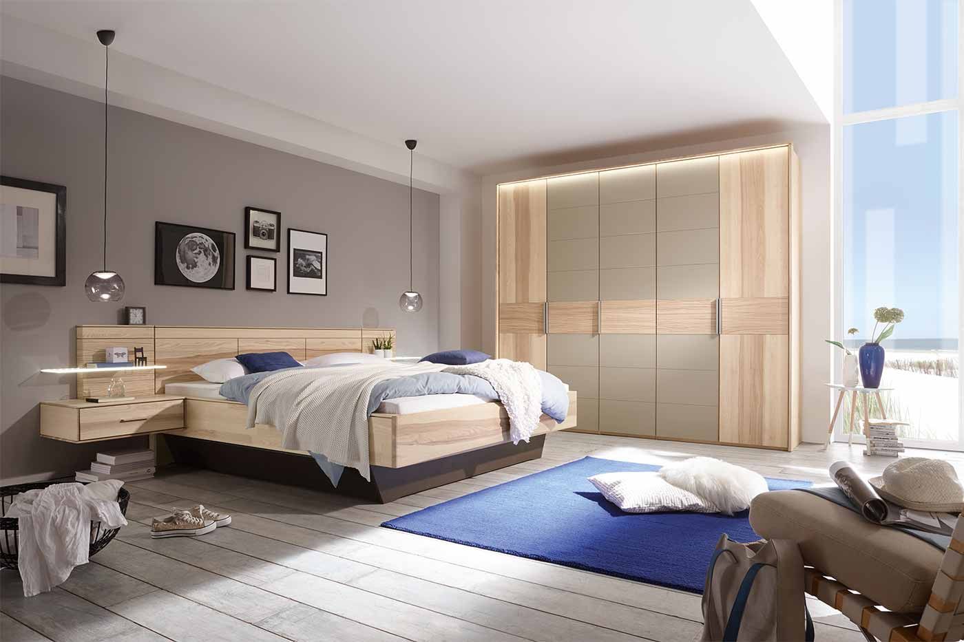 Großes Schlafzimmer mit grauem Fußboden und einem Holzbett, Holzschrank und blauen Dekorationen
