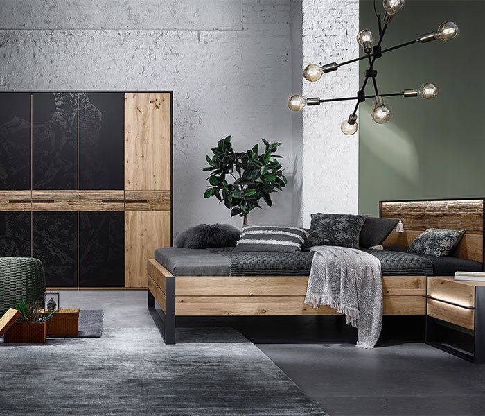 Schlafzimmer Mood 1 Schlafzimmer mit einem großen dunklen Holzbett und einem Schrank aus dem gleichen Holz