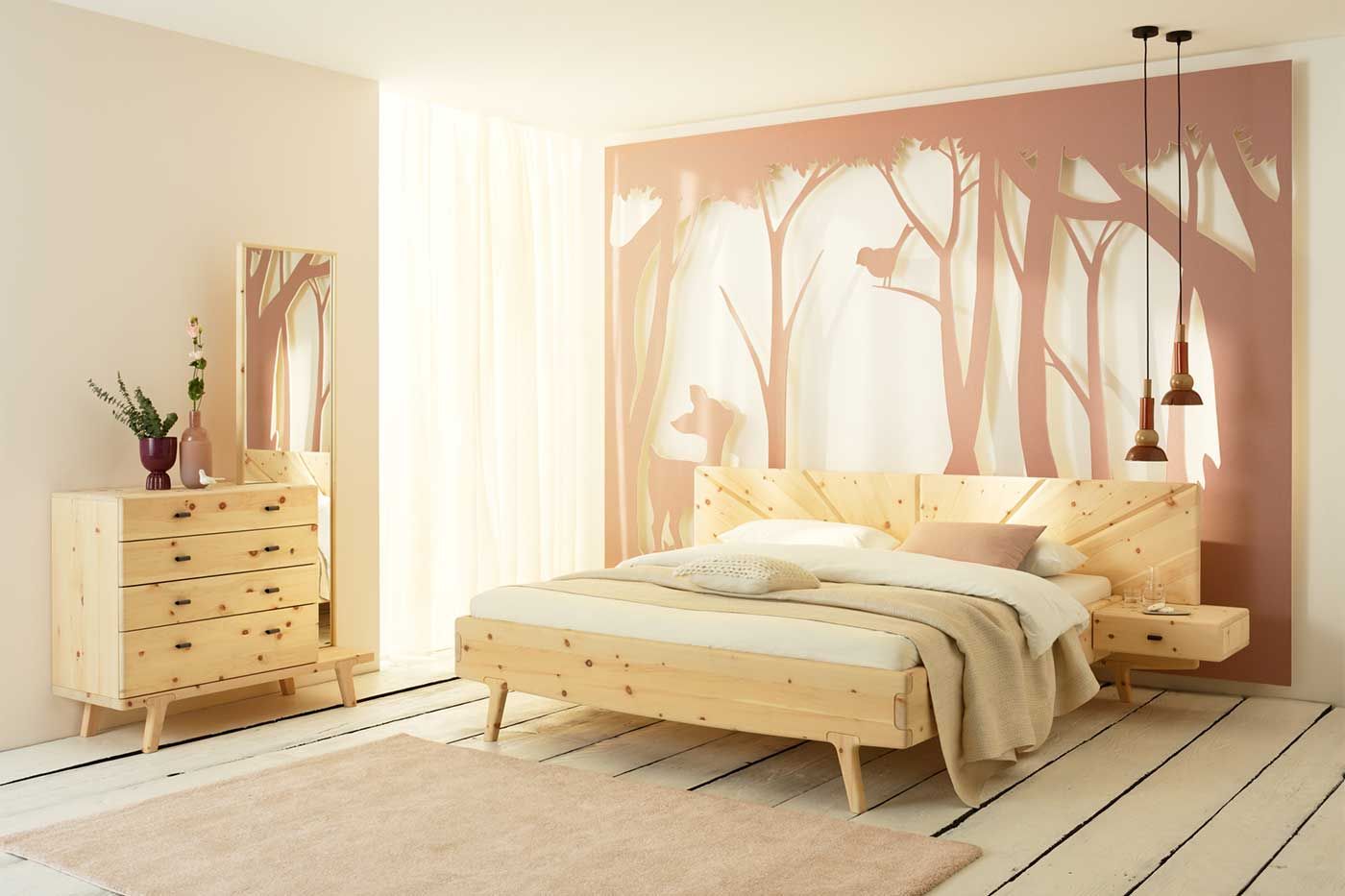 Bildergalerie Schlafzimmer Sol Helles Schlafzimmer mit einem Holzbett, Holzkommode und einem rosa Wandbild von einem Wald