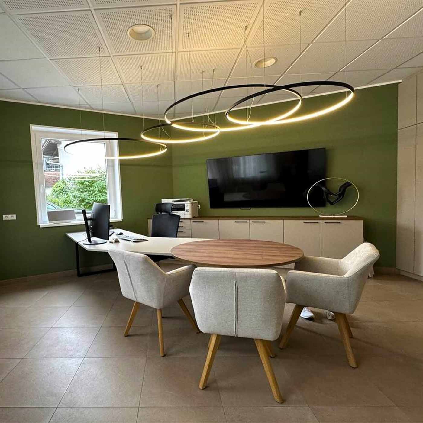 Helles Büro mit grüner Wand Ein helles Büro mit grüner Wand und großem Schreibtisch