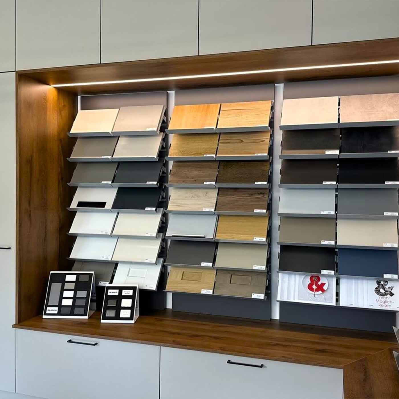 Vorführproben für Bodenläge In einem Wandschrank sind drei kleinere Regale auf denen Proben verschiedener Bodenbeläge ausgestellt sind