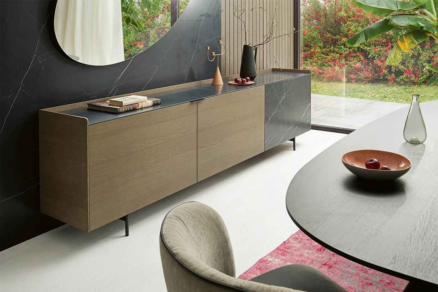 Sideboard aus Holz und mit mamorierten Schubladen vor einer mamorierten Wand